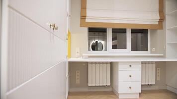 White built in desk with drawers under window in modern interior video