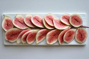 Fresh figs sliced and arranged on a white cutting board photo