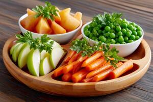 Healthy finger food presented on a wooden plate, including carrots, peas, apple and persimmon with parsley photo