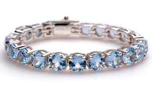 Silver bracelet featuring blue gemstones shining on white background photo
