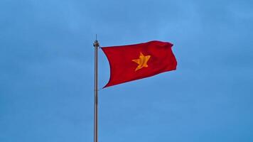 The Vietnamese flag flutters in the wind against a blue cloudy sky. Slow motion. A yellow star on a red background. video