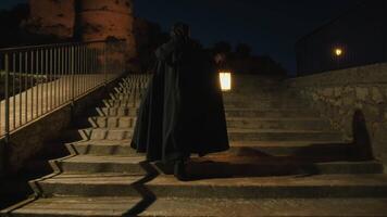 Woman With Mysterious Cloak Walks With Lantern At Night video