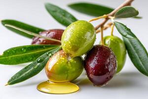 Fresh olives dripping oil with leaves covered in water drops photo