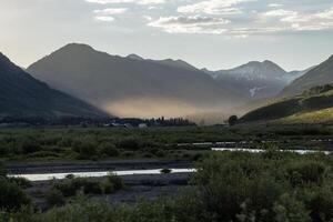 Natural landscape showcasing mountains and valleys during golden hour with gentle light illuminating the scene photo