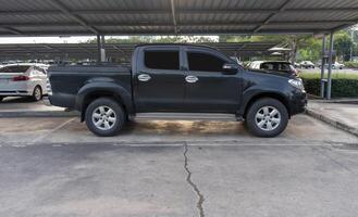 Black pickup truck with right side view parking at open area parking lot with roof of a department store photo