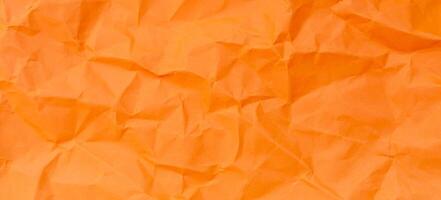 Full frame of wrinkled or crumpled orange paper texture used as crumpled paper background texture in decorative art work photo