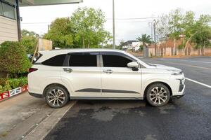White sport SUV car with right side view parking in open area in front of residence or house photo