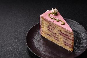A piece of pink layered cake with strawberry photo