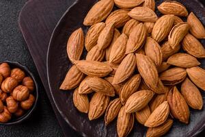 Roasted or raw almond nuts in shell in plate photo