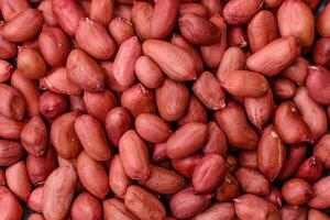 Peanuts in a bowl on a dark concrete background photo