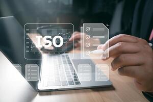 ISO standards quality control, assurance and warranty business technology concept. Businessman using laptop computer with quality assurance and document icon for ISO, ISO concept. photo