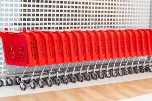 Red shopping carts in a row in the market photo