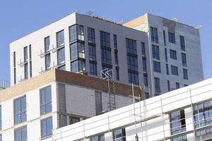 The process of insulating external walls in a multi-storey building under construction photo