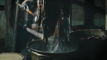 Boiling batik with hot water and soda ash to clean the wax that is still stuck. The traditional process of making indonesian batik video