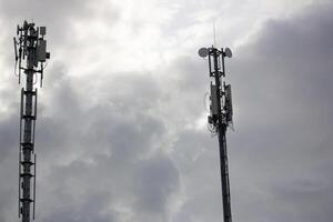 Two telecommunication towers under a cloudy sky, symbolizing connectivity, communication, and modern infrastructure technology photo