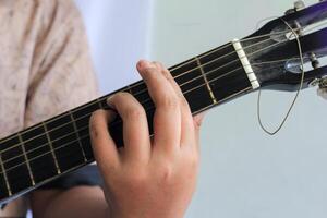 Detailed View of Hand Forming Chord on Guitar Fretboard photo