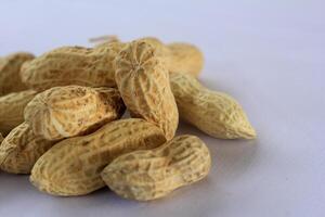 Organic peanuts in shell isolated on clean white studio backdrop photo