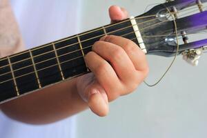Close-Up of Fingers Pressing Guitar Strings on Fretboard While Playing Music photo
