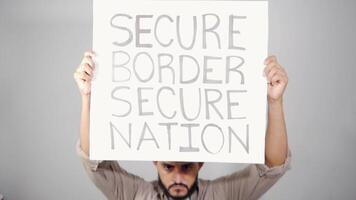 Activist showing secure border secure nation sign video