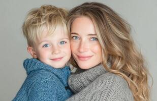 Happy mother and child in blue sweaters smiling photo