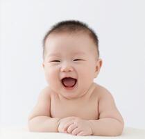 A baby laughing while sitting on a blanket photo
