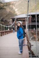 A girl in a blue jacket standing on a bridge photo