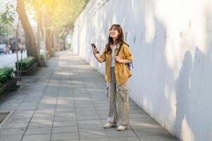 Asian woman standing on the street with her phone photo