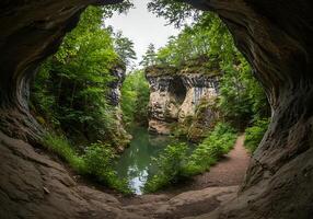 A view of a river through a cave in the woods photo