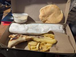 Empanada is a traditional Argentine dish. Empanadas, French fries and cheese sauce in a delivery box photo