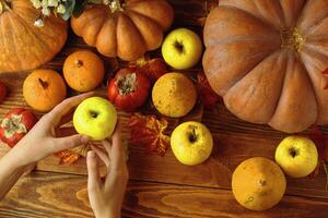 A pair of yellow and red pumpkins on a wooden table. Autumn harvest products, a piece of pumpkin photo