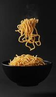 Noodle pasta Mie on black matte floating with dark background photo