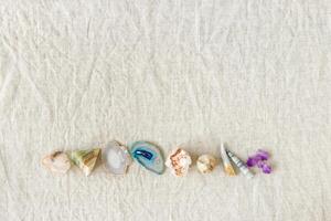 Row of crystals on table, healing minerals agate, quartz, amethyst, onyx, semiprecious gem. Stones for stone therapy, lithotherapy, rocks for ritual. Top view, flat lay with daylight photo