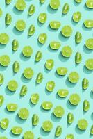 Lime fruit as bring summer food pattern, slices of green citrus with hard shadows at sunlight on pastel mint background. Healthy fruits food concept. Monochrome flat lay with juicy lime photo