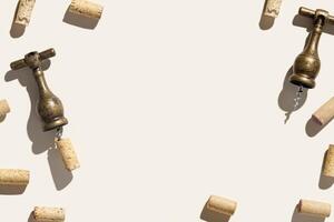 Wine corks and vintage corkscrew on beige background with shadows at sunlight. Minimal style layout with bottle cork, old bottle screw or opener, design concept for wine list, copy space photo