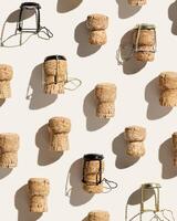 Pattern with champagne corks on beige background with hard light and shadow at sunlight. Summer wine drinks concept, bottle cap from sparkling wine and metal wire muselet, repeat pattern photo