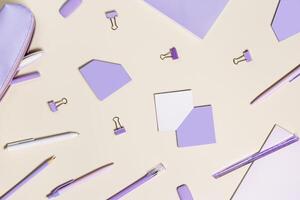 School stationery flat lay very peri trend color. Back to school concept, notebook, note, pen, paperclips on pastel beige background. Office equipment, view from above, minimal style photo
