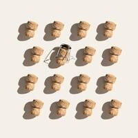 Creative pattern with champagne cork on beige background with hard light and shadows at sunlight. Minimal style layout with bottle cap from sparkling wine and metal wire muselet, top view. photo