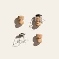 Creative pattern with champagne cork on beige background with hard light and shadows at sunlight. Minimal style layout with bottle cap from sparkling wine and metal wire muselet, top view photo