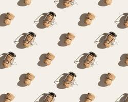 Creative pattern with champagne corkS on beige background with hard light and shadows at sunlight. Minimal style layout with bottle cap from sparkling wine and metal wire muselet, top view photo