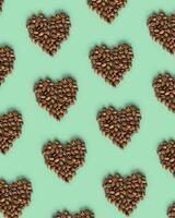 Shape heart from coffee beans on mint color background, roasted brown coffee berries, trendy design geometric pattern, top view, minimal flat lay photo