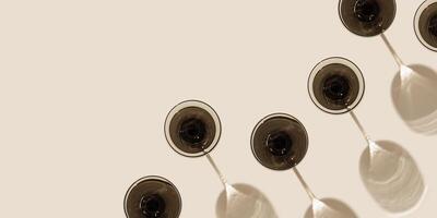 Creative pattern with champagne glass grey colored glass on beige background with hard shadows from sunlight. Summer drink concept. Trendy colored wine glass. Top view wide banner photo