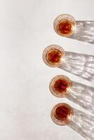 Crystal Whiskey Glasses with shadows at sunlight on beige textured background, minimal aesthetic flat lay shiny glasses, sun glare, stong alcohol drink concept, summer still life photo