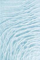 Clear blue water and waves at sunlight, sun flare and bright white reflections on blue, turquoise water surface. Summer vivid gradient color, graphic nature, dynamic aquatic ripples pattern, aesthetic photo