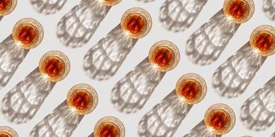 Crystal Whiskey Glasses with shadow at sunlight on beige concrete background, creative pattern, minimal aesthetic banner shiny glasses, sun glare, alcohol drink concept, summer still life, overview photo