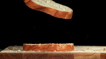 Sliced bread falls onto a cutting board. Filmed on a high-speed camera at 1000 fps. High quality FullHD footage video