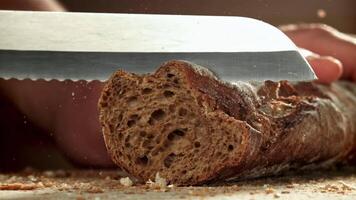 The chef slices bread. Fresh baguette sliced. Filmed on a high-speed camera at 1000 fps. High quality FullHD footage video