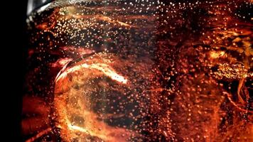 Bubbles in a glass of cola with ice. Filmed on a high-speed camera at 1000 fps. High quality FullHD footage video
