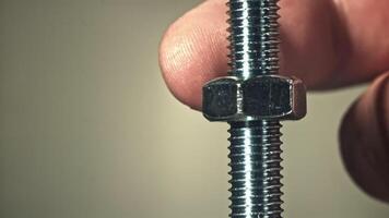 The nut is twisted on the thread of the bolt. Filmed on a high-speed camera at 1000 fps. High quality FullHD footage video