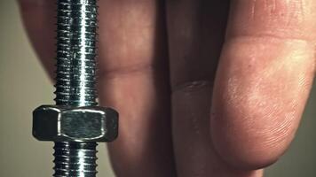 The nut is twisted on the thread of the bolt. Filmed on a high-speed camera at 1000 fps. High quality FullHD footage video