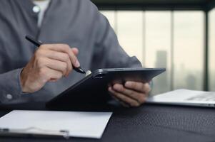Man Using Tablet with Stylus in Modern Workspace Setup photo